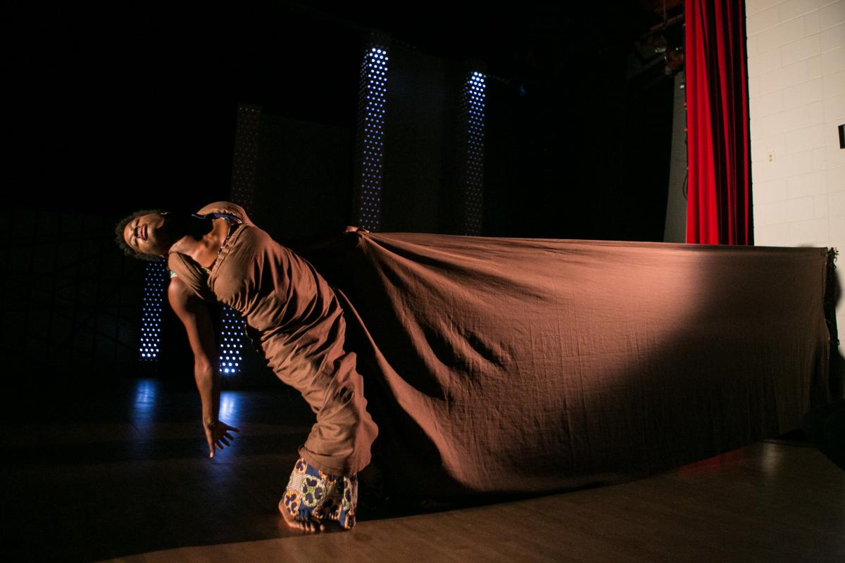 Dancer leaning to the left pulled by a drape